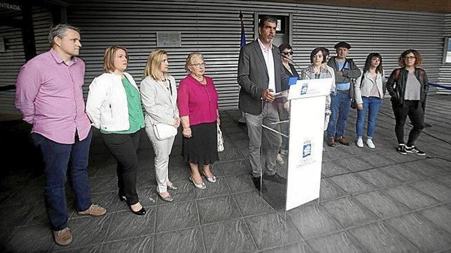 Los familiares de Ángel Portugal y Mikel Zabalza escuchan al alcalde de Donostia, Eneko Goia, a la entrada de la sede de Dbus, durante el acto de ayer.
