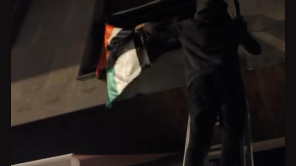 Un joven del gaztetxe en el momento de arrancar la bandera palestina del batzoki de Azpeitia