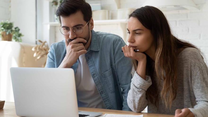 Dos jóvenes buscando vivienda en Internet.