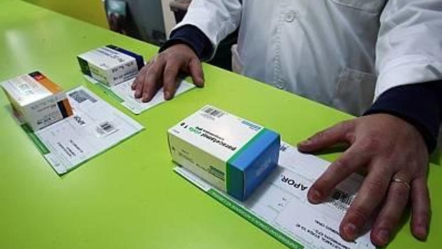 Un farmacéutico con varias cajas de medicamentos genéricos.
