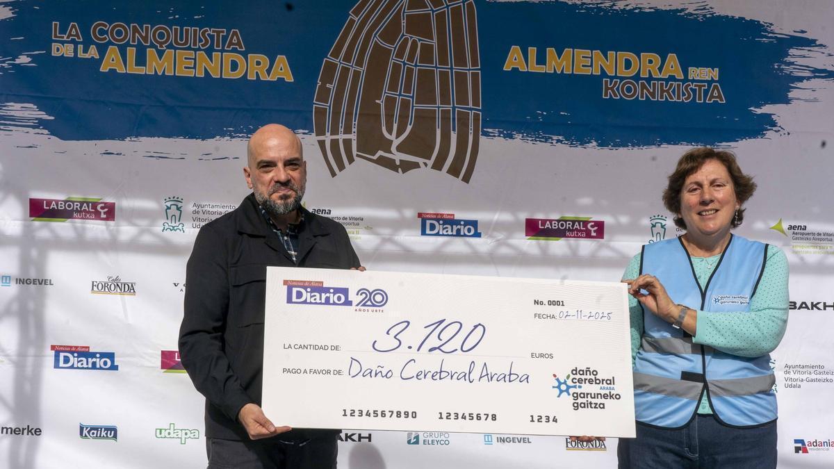 César martín, director de Diario Noticias de Álava, entrega el cheque a la representante de Dañor Cerebral Araba