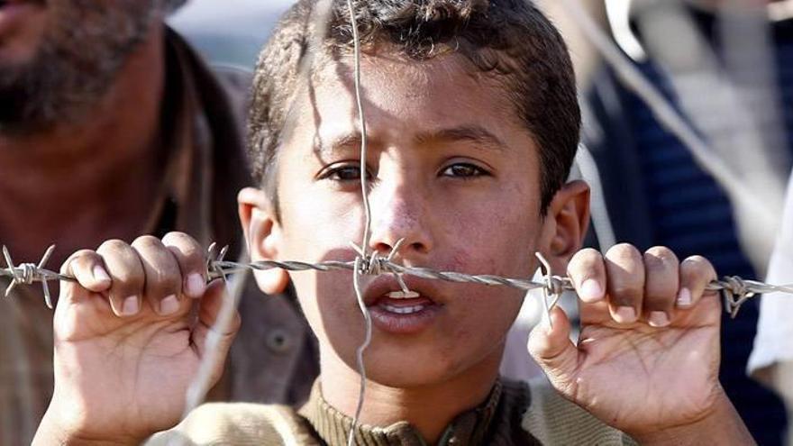 Un niño kurdo espera tras una alambrada a ser trasladado a un campo de refugiados tras cruzar la frontera desde Yumurtalik por la violencia del Estado Islámico (EI).