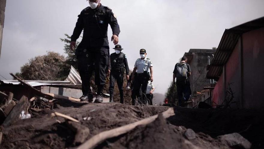 GU1001. ESCUINTLA (GUATEMALA), 11/06/2018.- Policías caminan hoy, lunes 11 de junio de 2018, en el área del desastre luego de la erupción del volcán de Fuego el 3 de junio de 2018, San Miguel Los Lotes, Escuintla (Guatemala). El volcán de Fuego de Guatema