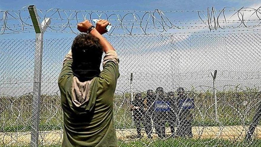 Un refugiado, ante una patrulla militar macedonia.