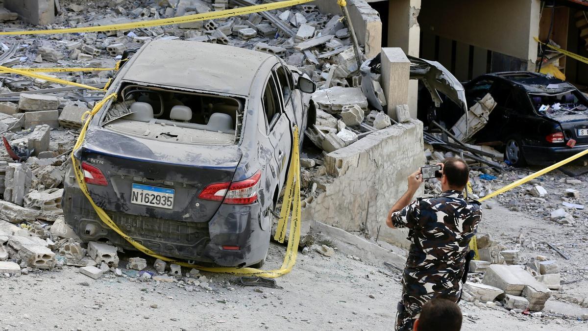 Un hombre fotografía un vehículo dañado por un bombardeo de Israel en el sur de Líbano