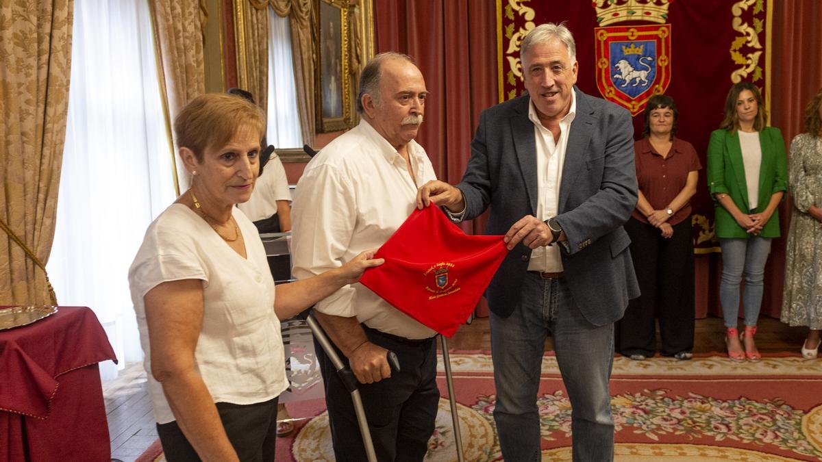 Los hermanos de Mari, Juan y Marisol Ganuza Senosiáin, reciben el Pañuelo de la mano del alcalde.
