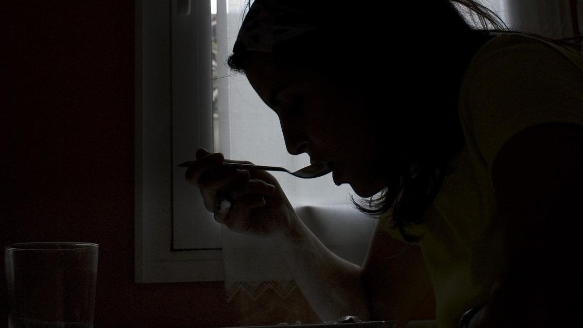 Una joven, aislada, comiendo en su domicilio