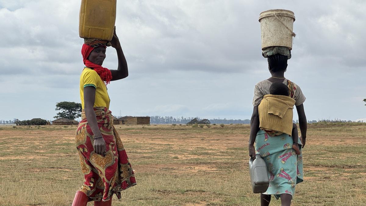 Mujeres regresan a sus casas con el agua del pozo.