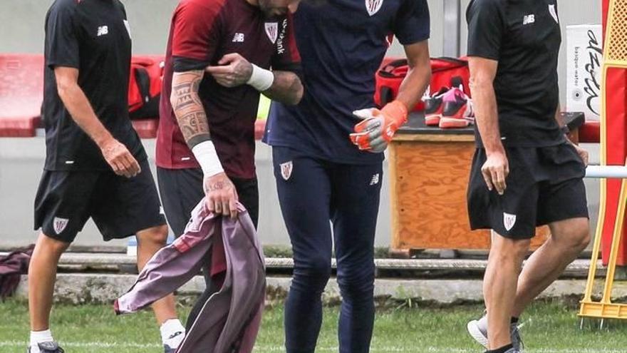 El portero del Athletic de Bilbao, Iago Herrerín (c), se retiró antes del entrenamiento tras sufrir una lesión muscular en el brazo