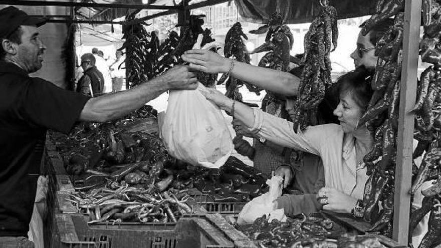 Un vendedor entrega una bolsa de pimientos asados de unos 10 kilogramos, este fin de semana en el mercado de Gares.