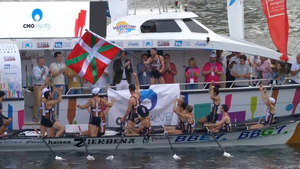 El patrón de Zierbena, Aitor Lazkano, agita la bandera ganadora en Pasai Donibane