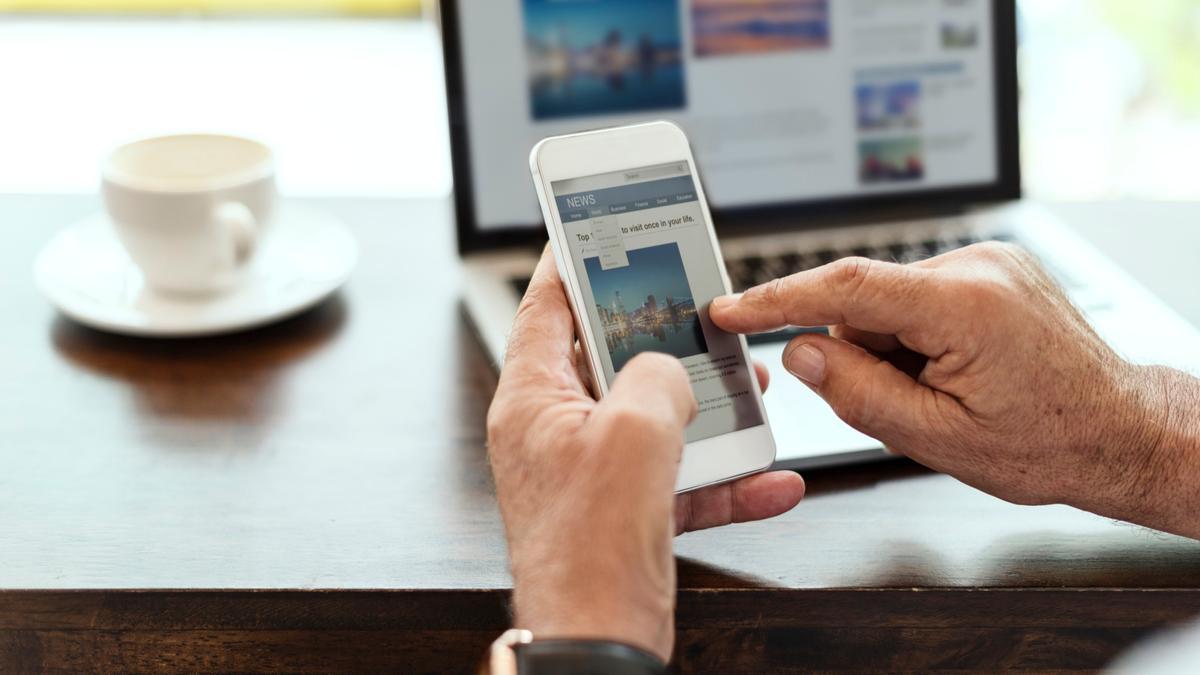 Un hombre consulta noticias en su teléfono móvil. Un hombre consulta noticias en su teléfono móvil.