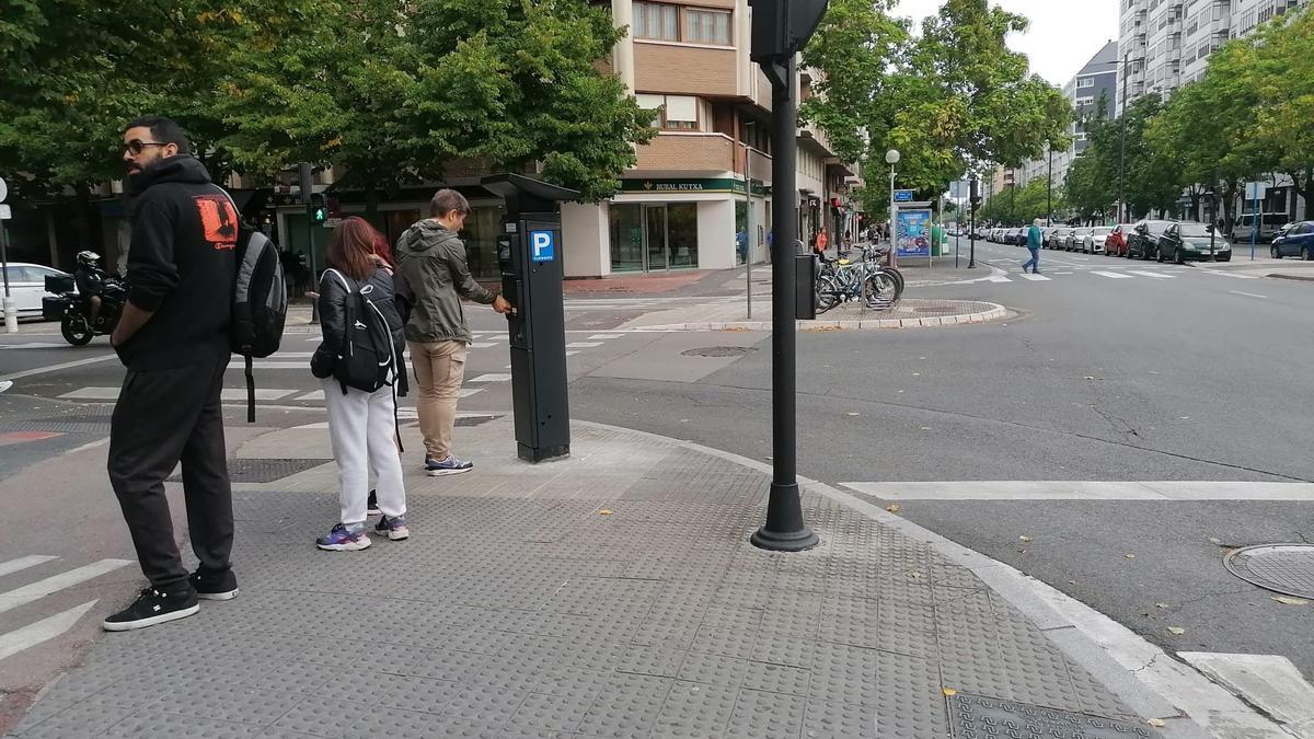 Varias personas sacan el ticket de la OTA en los parquímetros de San Martín y Avenida Gasteiz