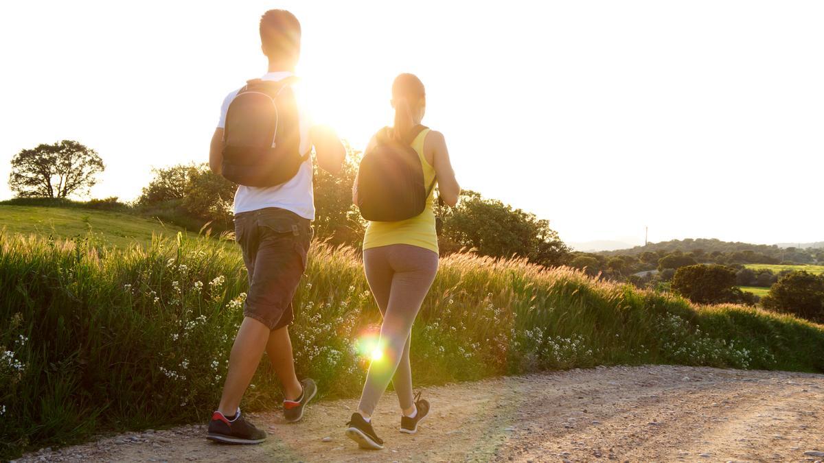 Una pareja camina al atardecer.