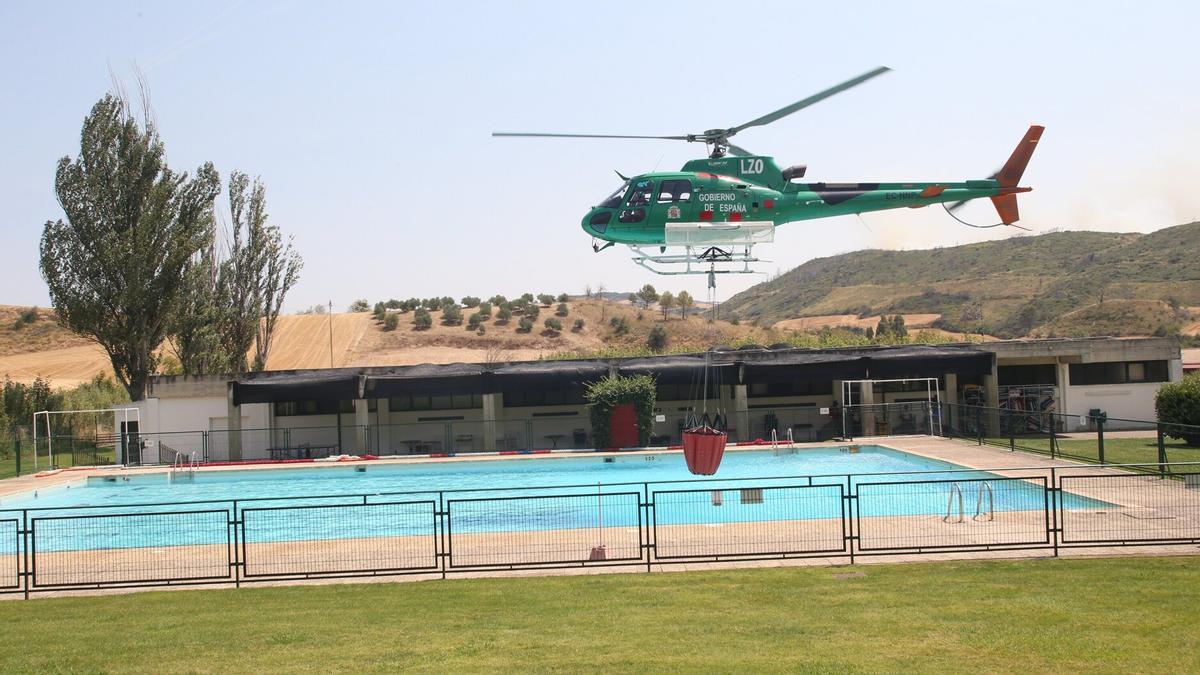 Un helicóptero, cogiendo agua de la piscina de Obanos para la extinción del incendio de Valdizarbe.