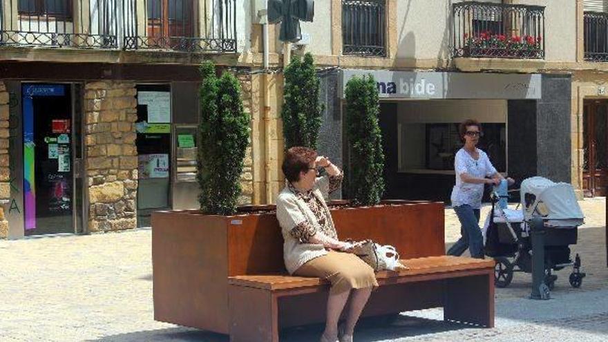 Una mujer disfruta del sol en una de las nuevas jardineras con banco de Lege Zaharren enparantza.