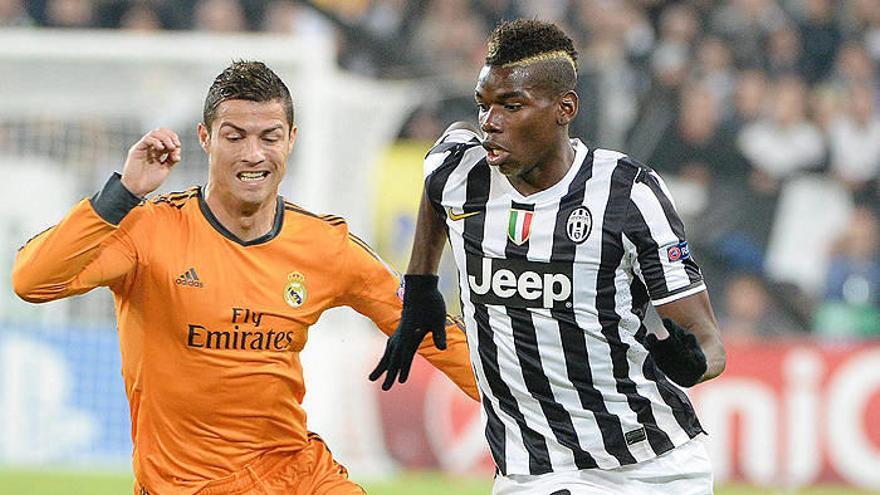 Pogba pugna por un balón con Cristiano Ronaldo.