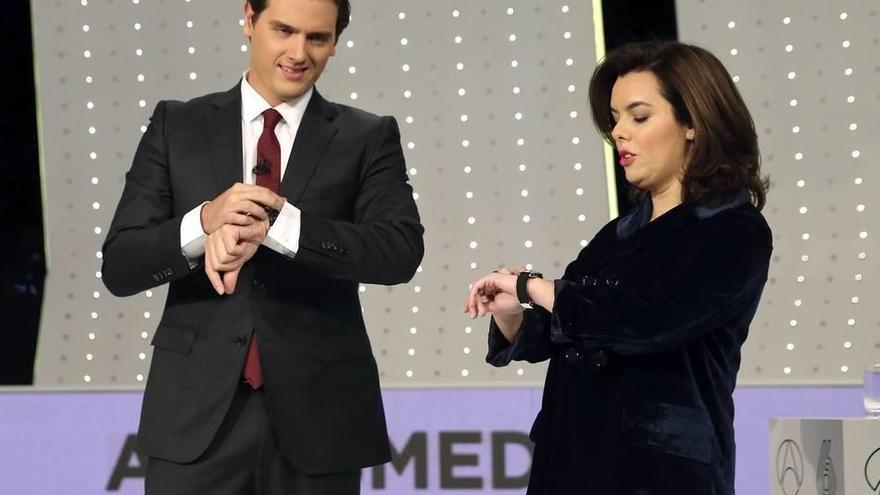 El presidente de Ciudadanos, Albert Rivera, y la vicepresidenta del Gobierno y candidata por Madrid al Congreso, Soraya Sáenz de Santamaría, consultan sus relojes antes del debate televisivo