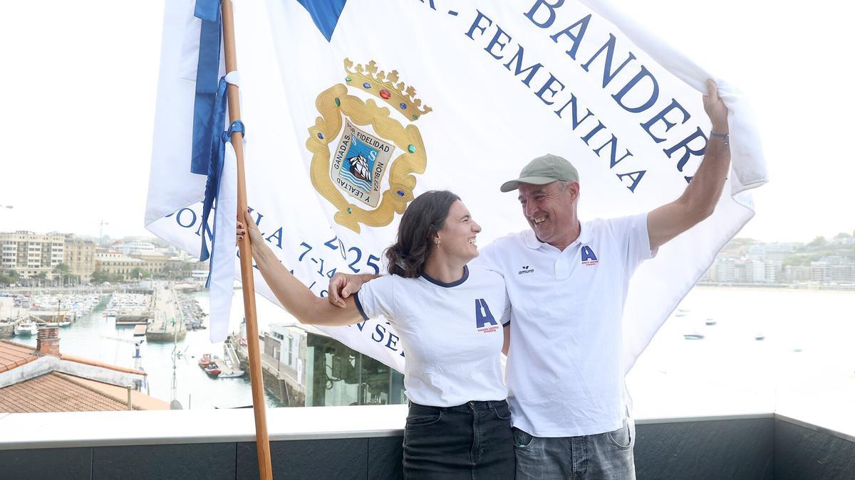 Lorea Etxabe y Juan Mari Etxabe posan con la Bandera de la Concha 2025 en el Aquarium