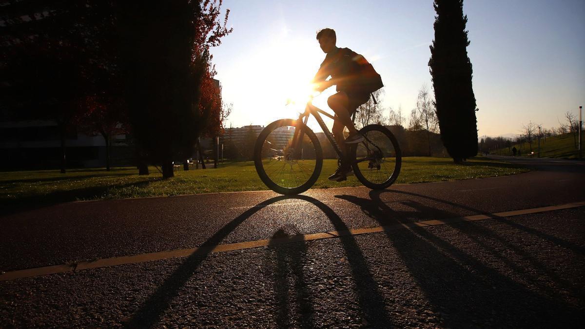 Un ciclista, a contraluz por los rayos del sol