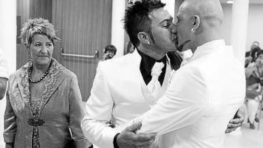 Dos hombres se besan durante su ceremonia de boda.