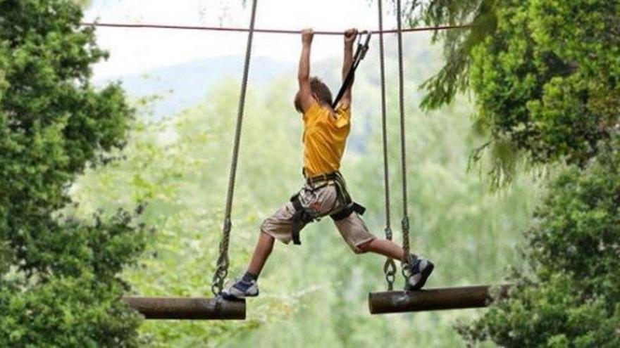 Un niño, atado con un arnés, durante un recorrido.
