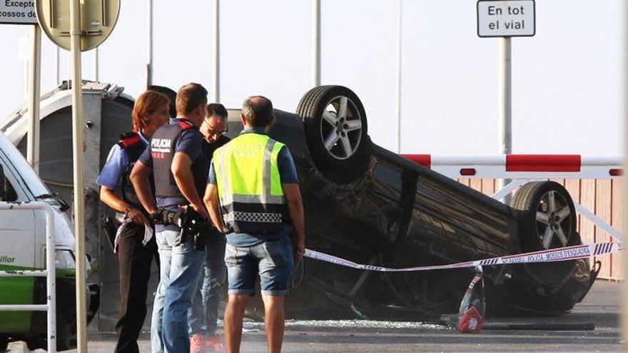 Agentes de los Mossos d’Esquadra, en la madrugada del viernes en el paseo marítimo de Cambrils con el coche del atentado.