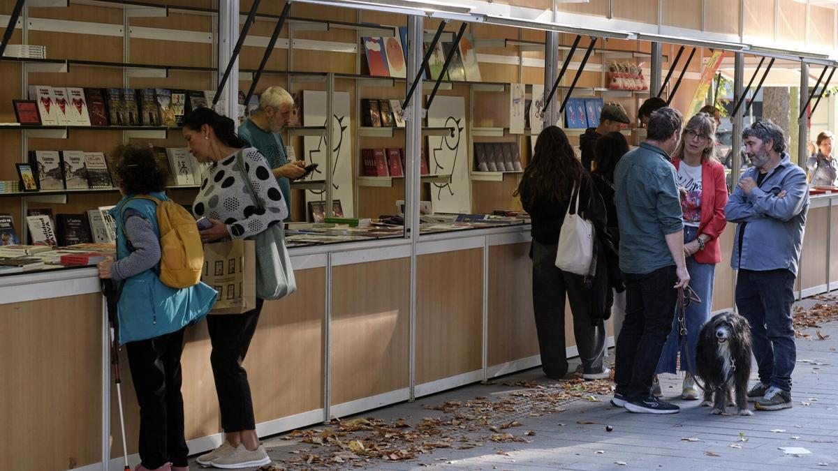 Varias personas se acercan a las casetas ubicadas en el Bosquecillo en busca de un libro de editorial navarra.
