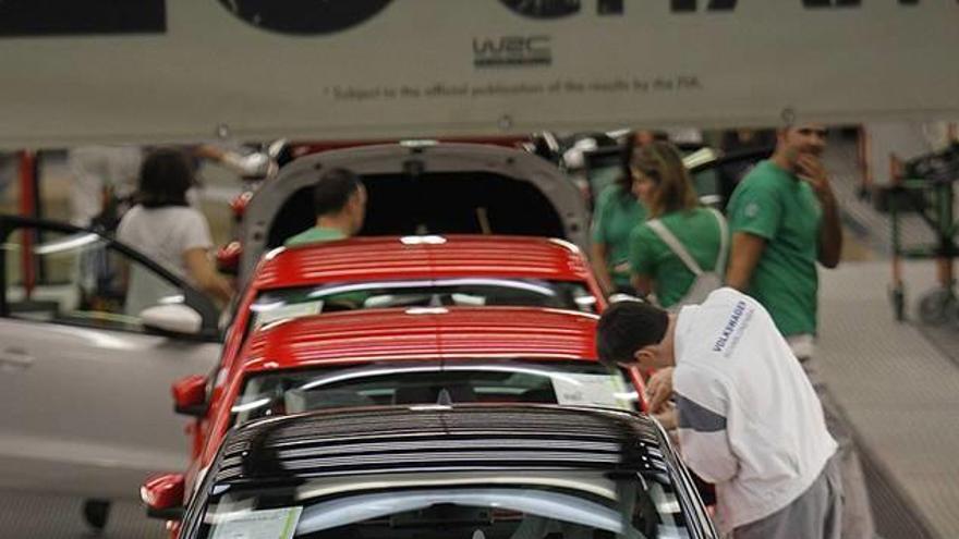 Varios empleados trabajan en la cadena de montaje en VW.