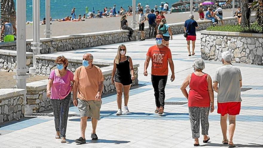 Varias personas disfrutaban ayer del buen tiempo caminando por el paseo marítimo Antonio Banderas de Málaga. Foto: Efe