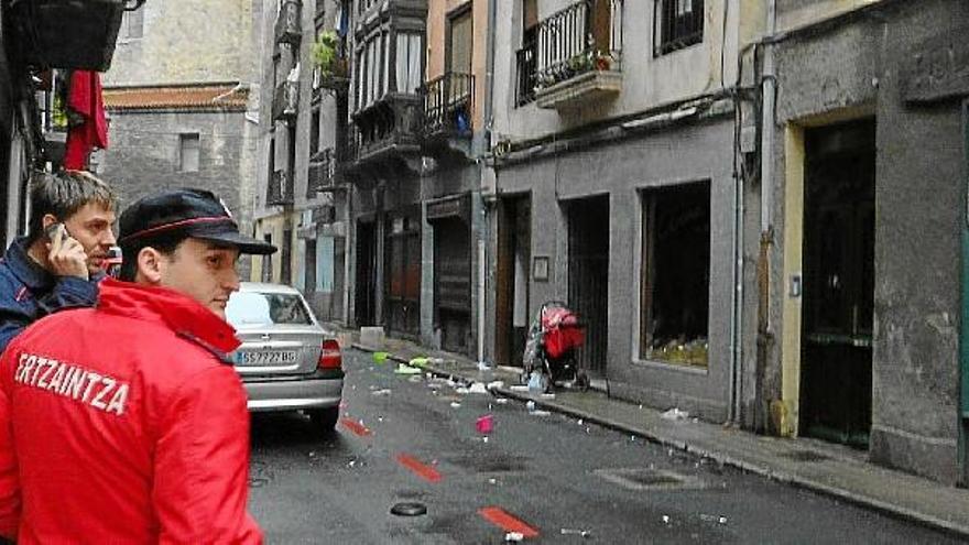 Un ertzaina junto al precinto policial que ayer por la mañana impedía el paso al número 3 de la calle Beotibar de Tolosa, lugar del crimen.