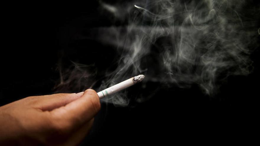 Una persona porta un cigarro encendido.