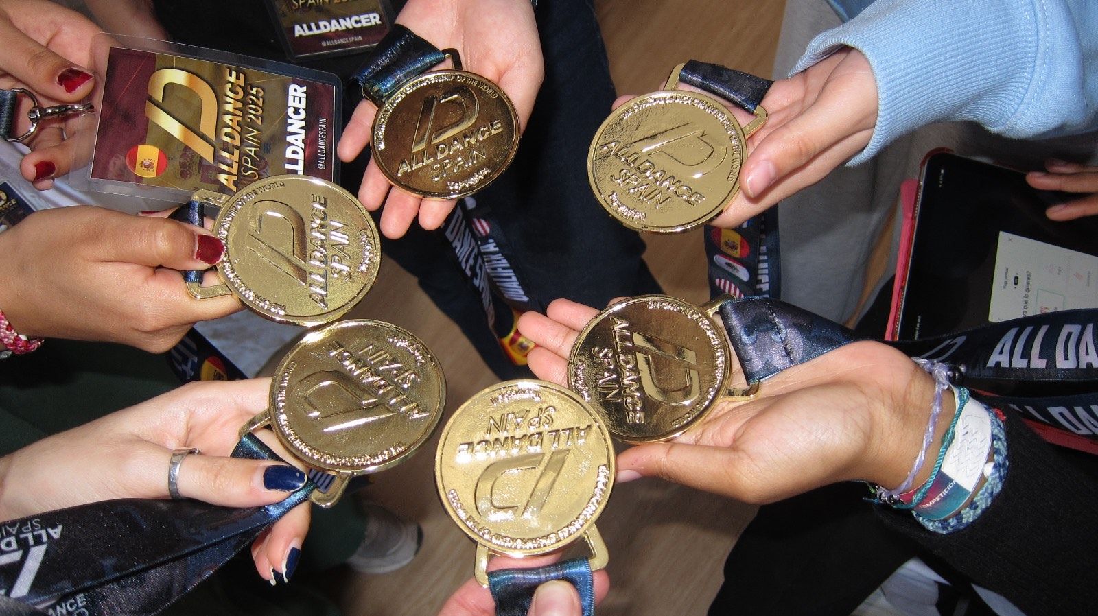 Las medallas que simbolizan la clasificación para la final mundial en Orlando, en manos de los y las bailarinas del grupo navarro HAZE.