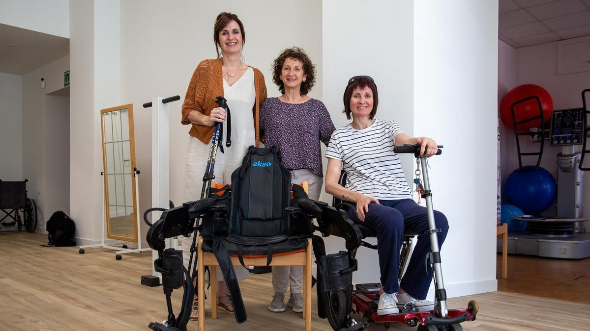 Desde la izquierda, Silvia Lorea, Isabel Campanón y Arantxa Medina, junto al exoesqueleto en la asociación.