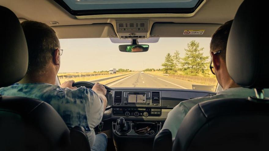 Dos personas conduciendo un coche por la autopista.