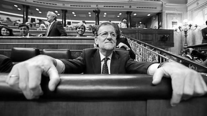 Mariano Rajoy se aferra a su escaño durante el debate de investidura.