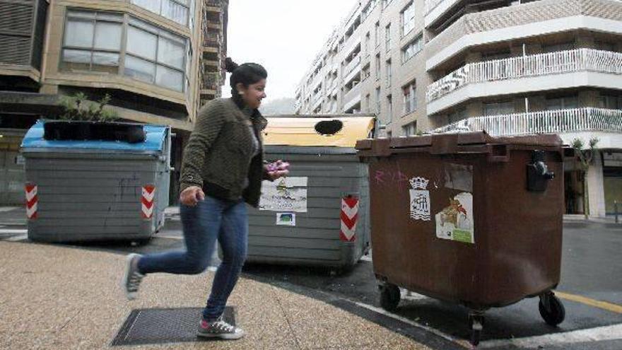 Una joven pasa por delante de uno de los contenedores instalados en las calles de Gros.
