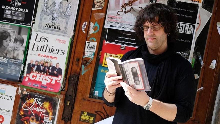 Ion Andoni, con su libro-casete entre las manos y con variada cartelería musical a sus espaldas.