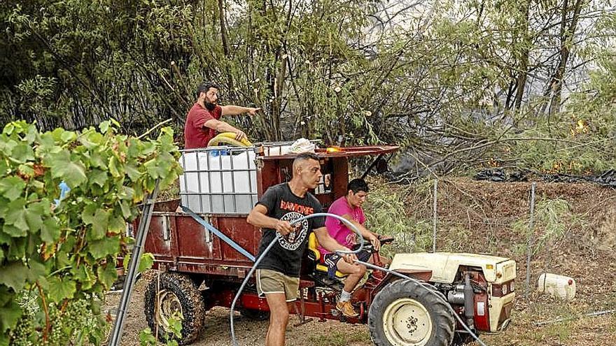 Vecinos combaten contra las llamas en Beade.  |  
