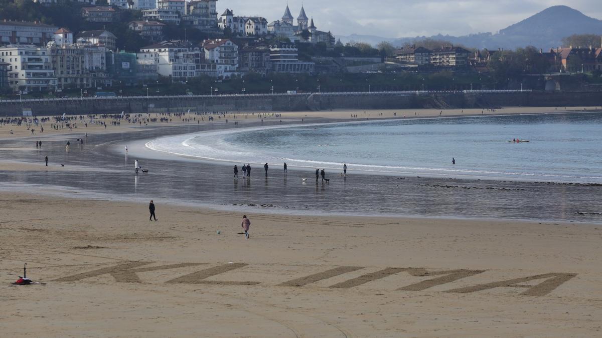 Imagen de una protesta contra el cambio climático en la playa de La Concha, donde puede leerse escrita en la arena la palabra &quot;klima&quot;.