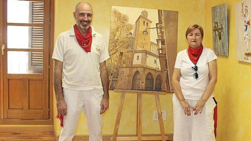 Fernando González y Tere Ayesa, junto al cuadro que anuncia la muestra.