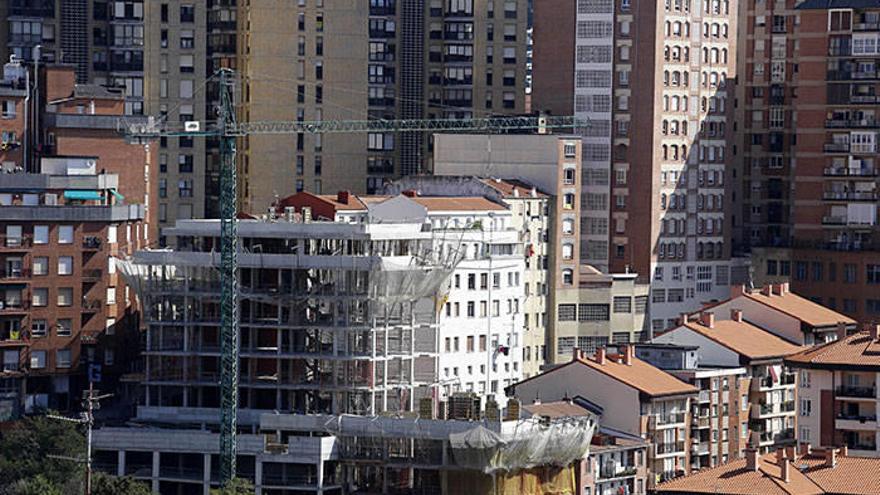 Imagen de un bloque de viviendas en construcción junto a varios edificios de viviendas en la capital vizcaina.