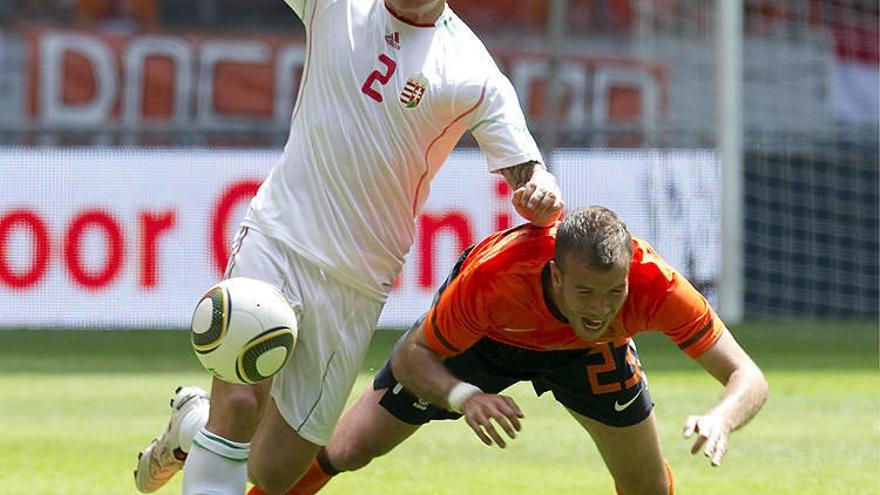 Van der Vaart (d) cae al suelo en su lucha por el balón con el húngaro Laszlo Bodnar durante el partido amistoso.