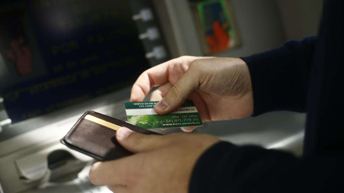 Una persona se dispone a sacar dinero de un cajero automático.