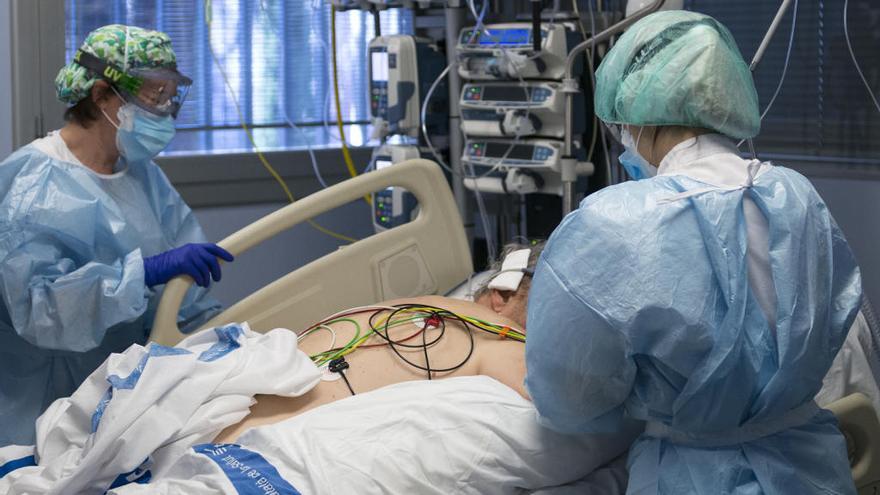 Personal sanitario atiende a un paciente ingresado en la UCI por covid.