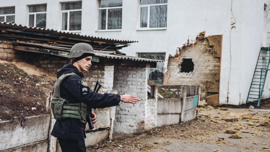 Un policía da instrucciones frente a una guardería donde ha impactado un proyectil en Stanitsa Luganska.