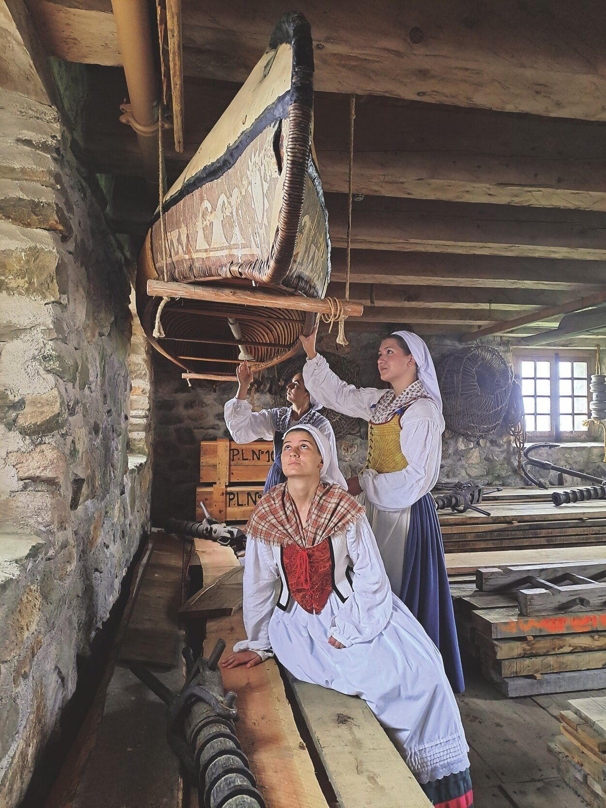 Maddi, Emma y Elaia, voluntarias de Jauzarrea para el programa de recuperación de la cultura vasca en Louisbourg, contemplan la canoa Mi&#039;kmaq en el almacén De la Vallière.