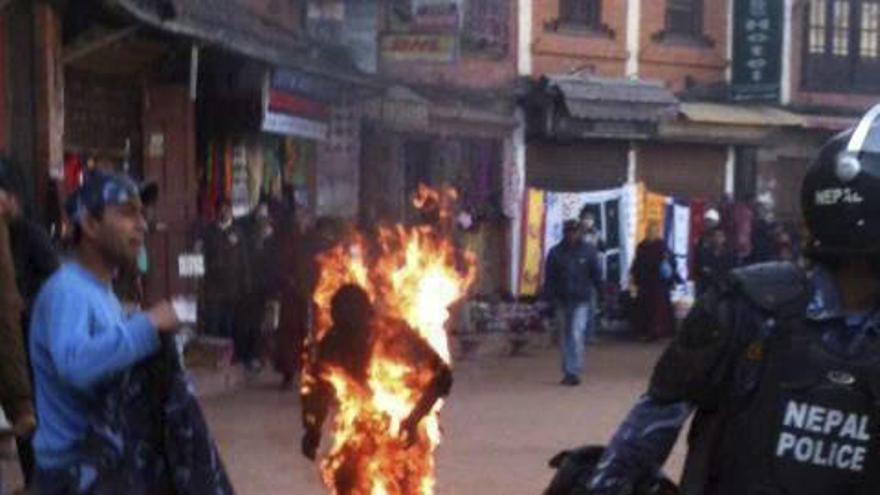 Un monje tibetano se quema a lo bonzo frente a un templo en el área de Bouddha, en Katmandú