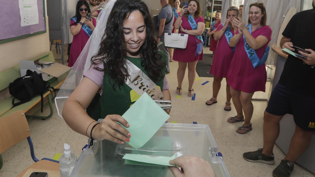 Una joven con velo y disfrazada para celebrar su despedida de soltera se dispone a introducir su papeleta de voto en una urna del IES La Caleta en el barrio de La Viña en Cádiz, hoy domingo 19 de junio cuando se están celebrando los duodécimos comicios autonómicos andaluces. EFE/Román Ríos.