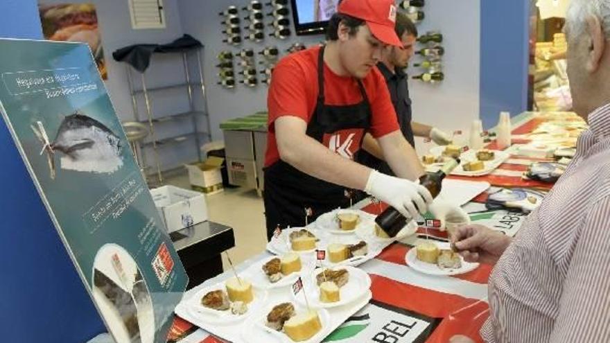 Una persona da a probar pintxos de bonito del norte y atún rojo eb un puesto de Eusko Label.